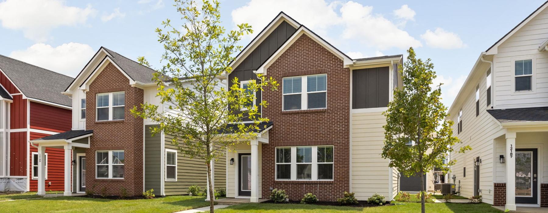 a brick house with a tree in the front